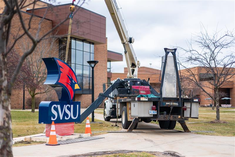 a crane lifting a sign