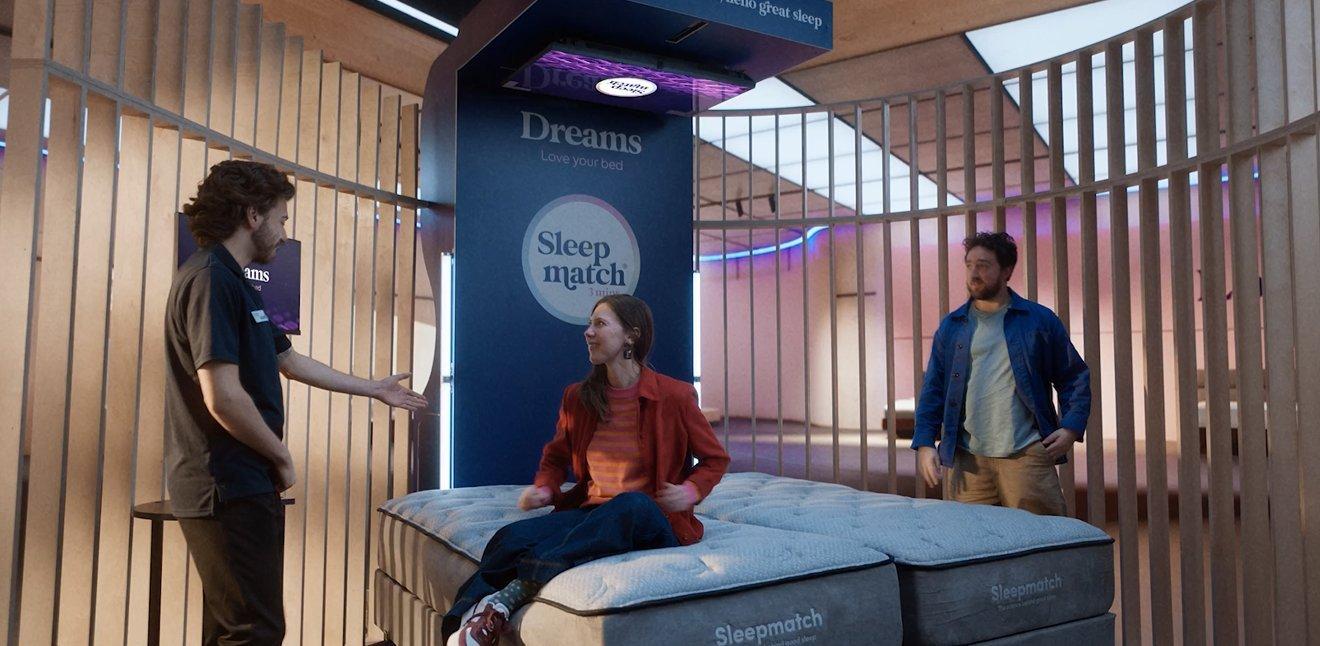 Sleepmatch people in store sitting on machine Sleepmatch people in store sitting on machine