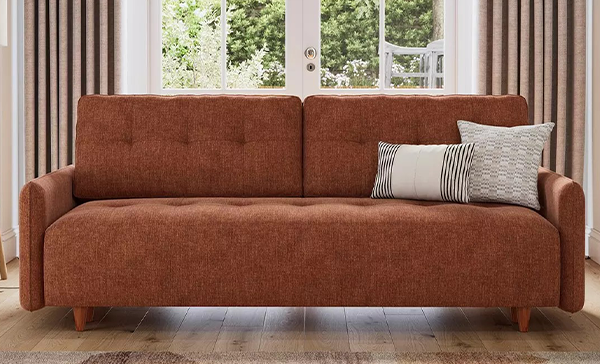 a couch with pillows in front of a window a couch with pillows in front of a window