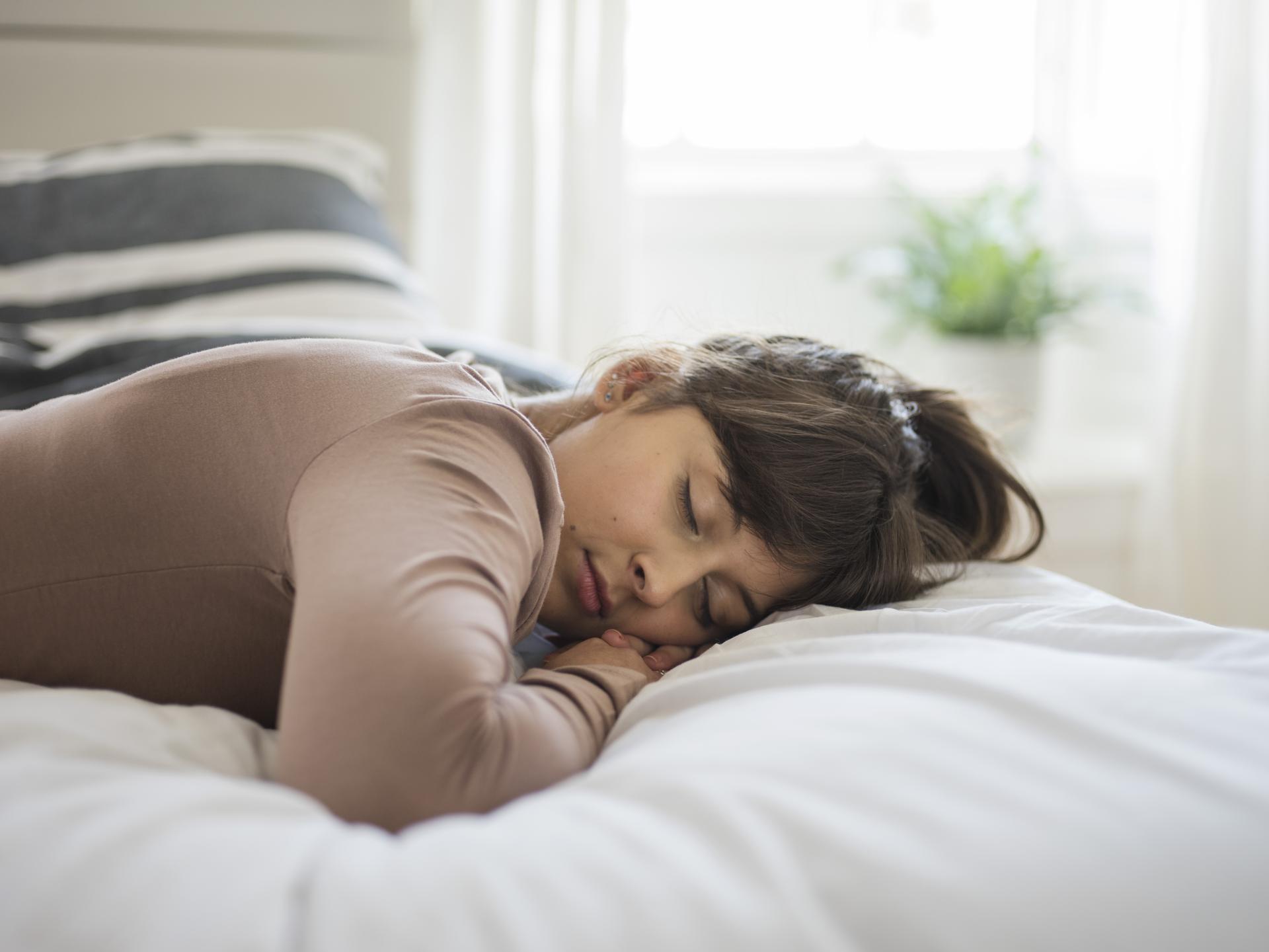 a woman sleeping on a bed a woman sleeping on a bed