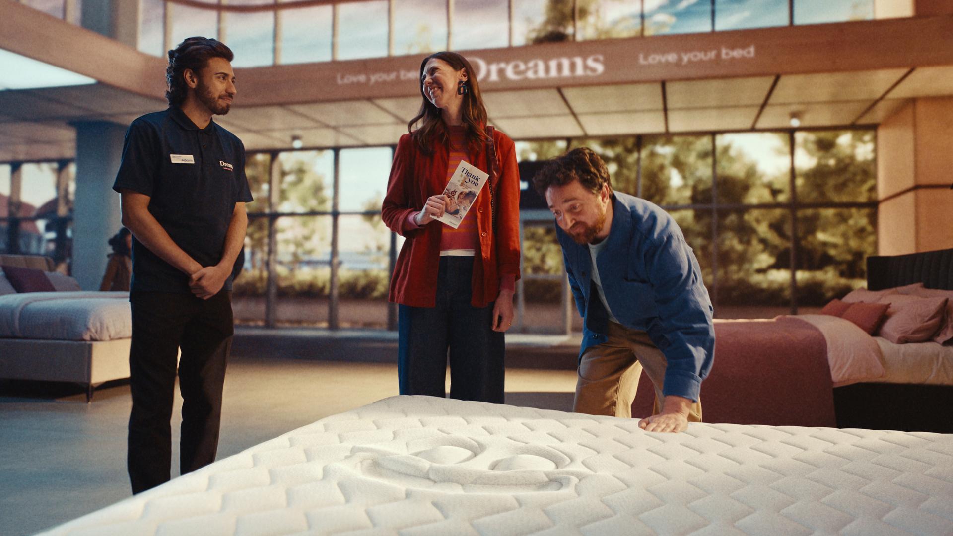 a group of people standing around a mattress a group of people standing around a mattress