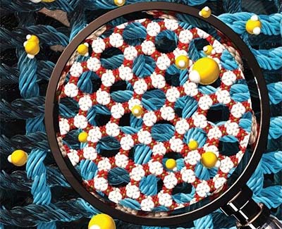 Illustration featuring a magnifying glass provides a close up view of threads and chemical molecules