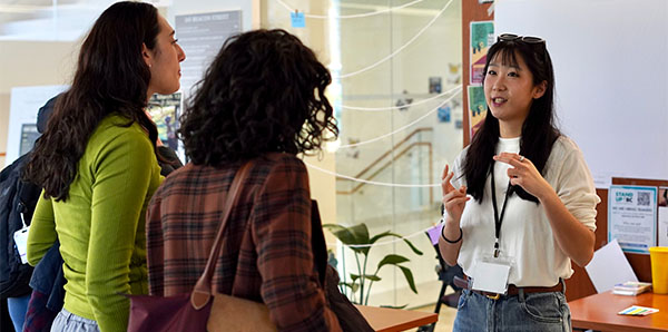 Three women talking at a conference.