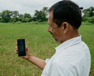 Man holding a phone while standing in a field