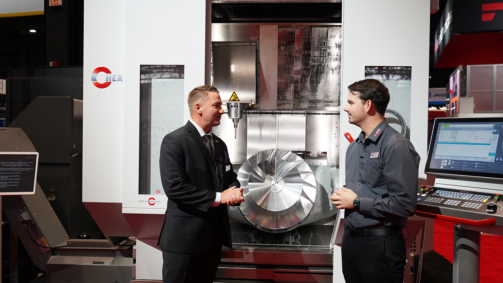 HERMLE representatives discussing machined part