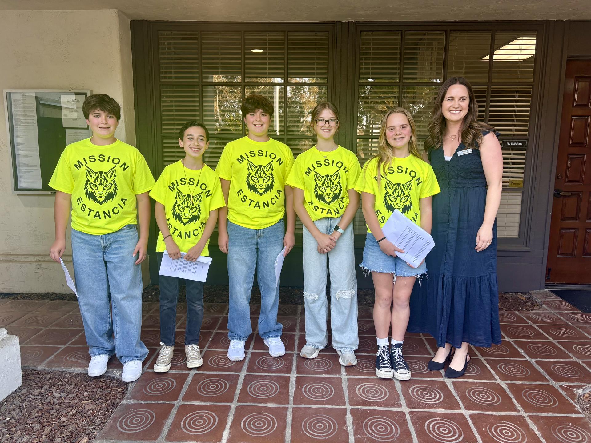 Five students stand next to their principal smiling.