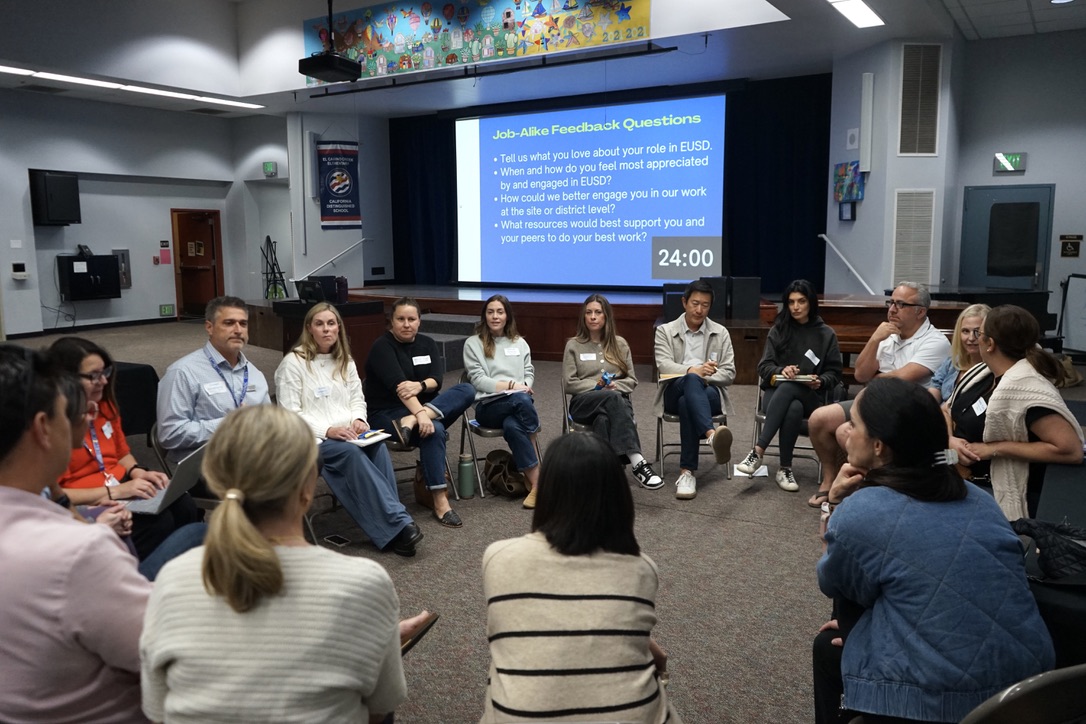 20 adults sit in a circle having an open discussion
