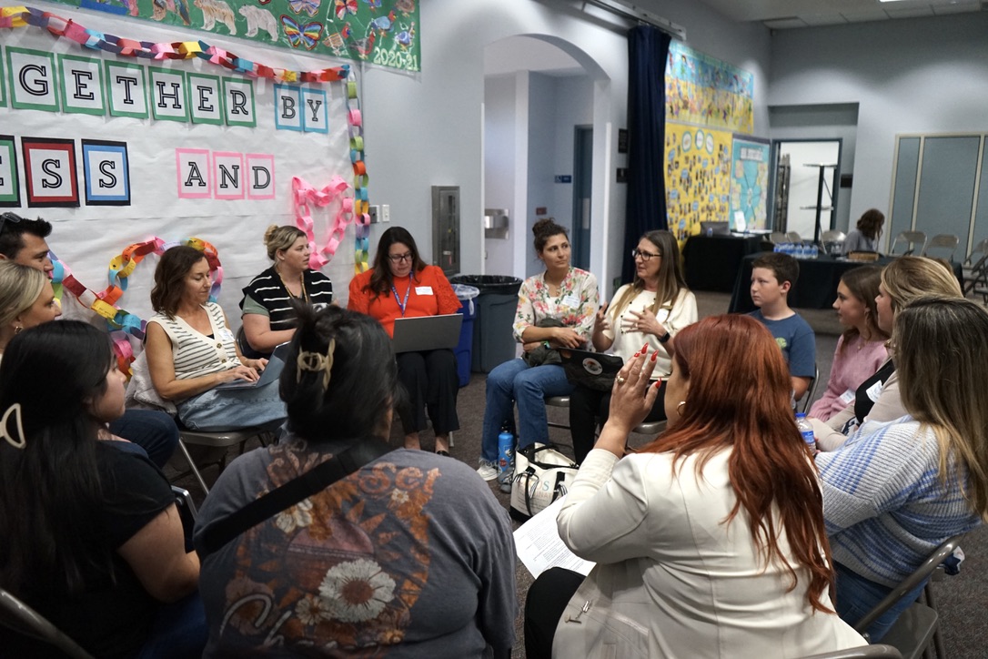 12 people sit in a circle having a discussion