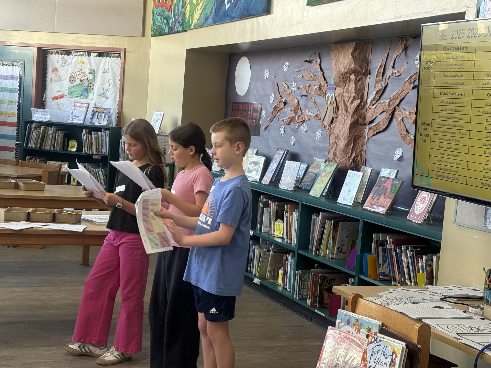 Students present to visiting families participating in a school tour. 