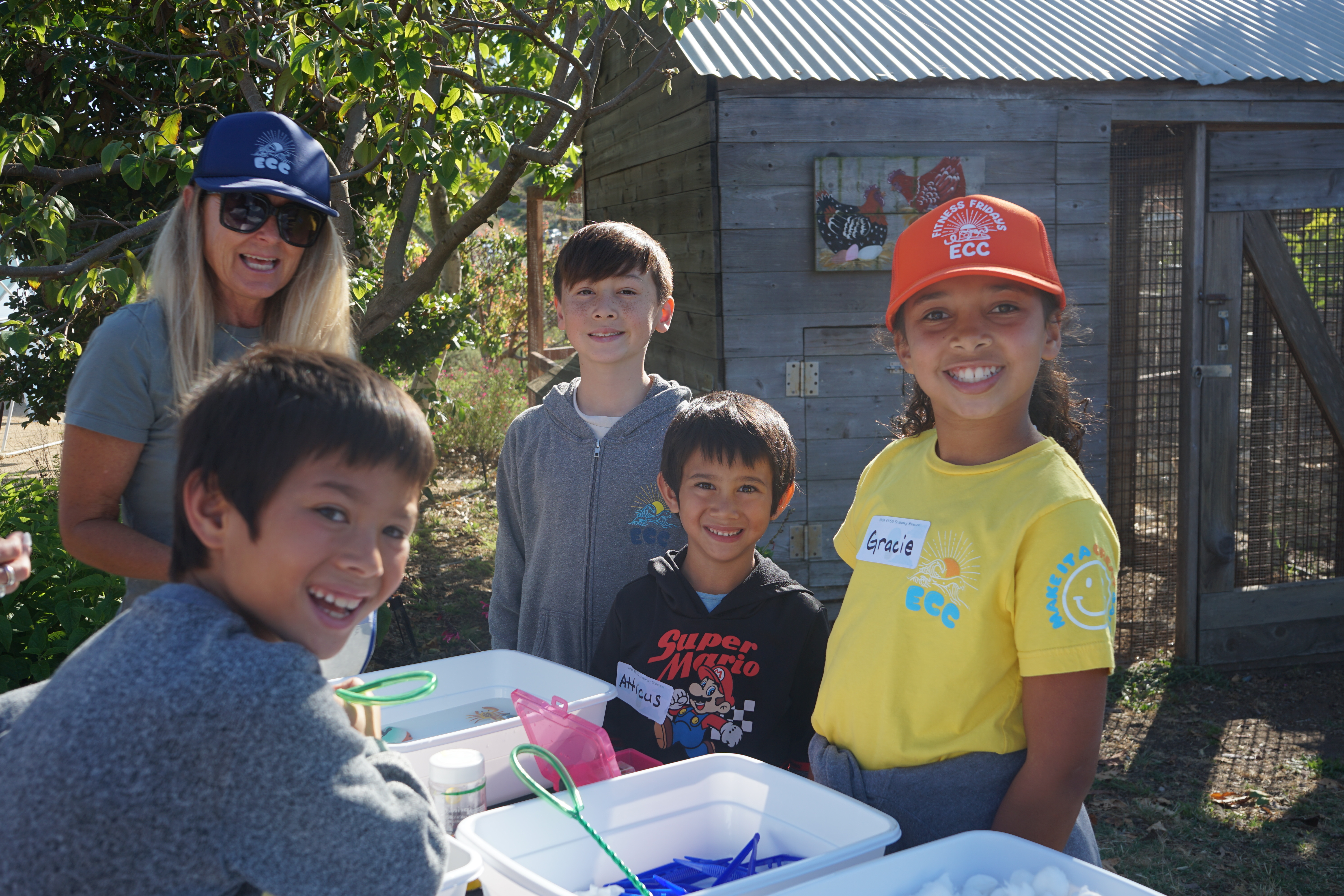 Four students smile for a photo at their booth. 