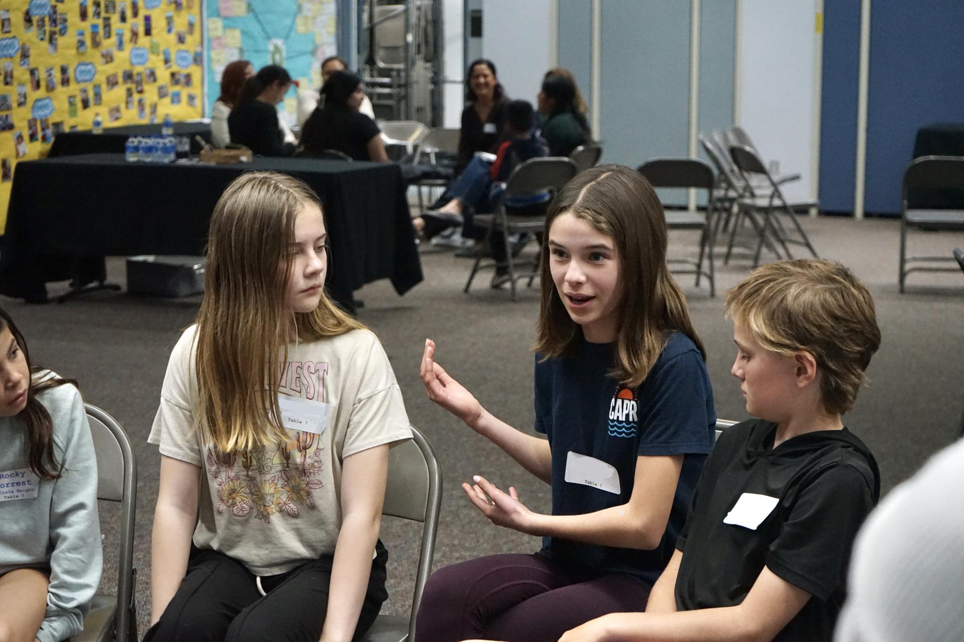 3 Students participating in a group discussion.