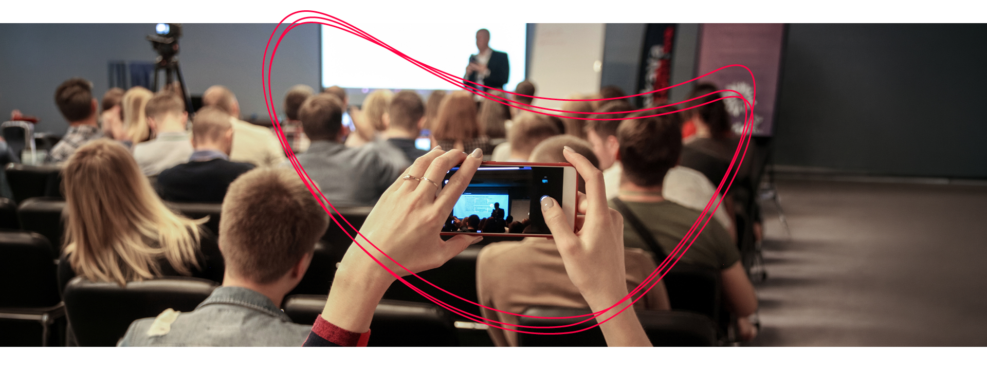 Eine Gruppe Menschen schaut gemeinsam nach unten auf etwas, das außerhalb des Bildes liegt.