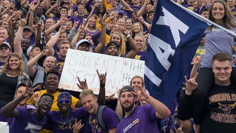 Students at an event show excitement and hold up the 