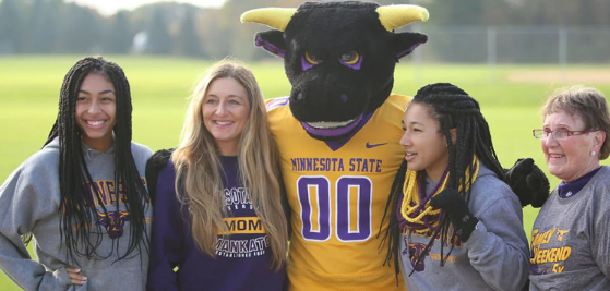 MSU mascot, Stopmer, takes photo with four others, all in MSU branded clothing.