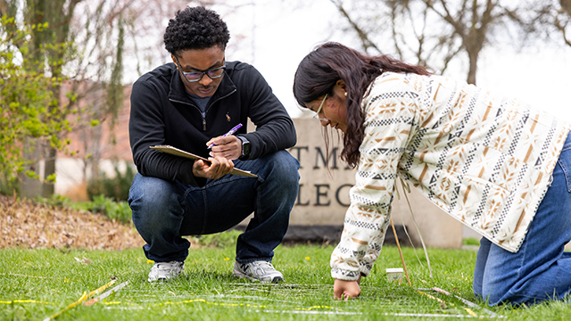 Jordan Tillman and Ashley Sontay Tzun examining a patch of lawn