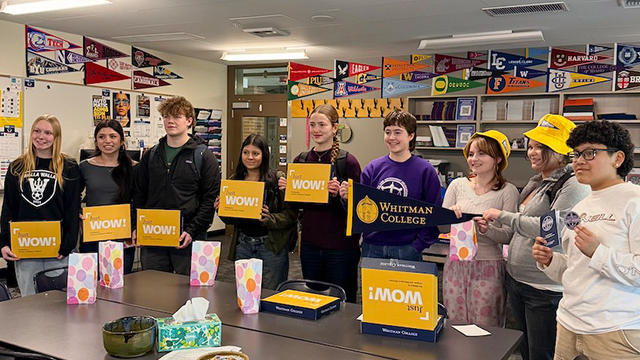 A group of Wa-Hi students holding boxes and wearing swag from Whitman College