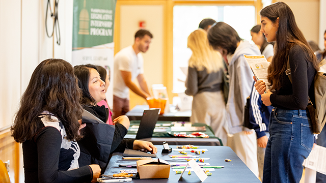 Students talking to people at information tables 