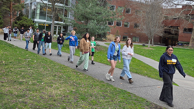 Visiting students following a Whitman student on the sidewalk by the Hall of Science.