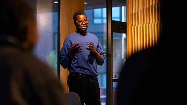 Deo Rubangakene speaks to an unseen audience in the Harvey Hall lounge