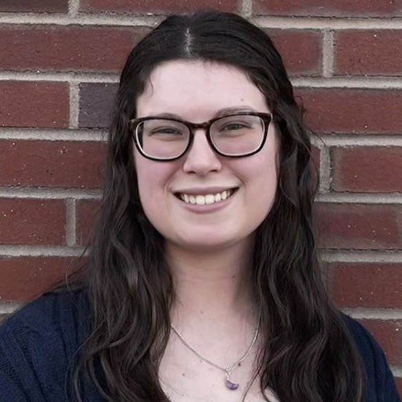 Natalie Price standing against a brick wall