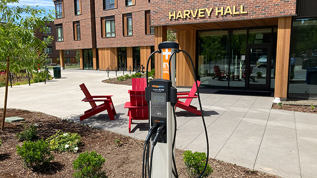 An electric vehicle charging station in front of Harvey Hall