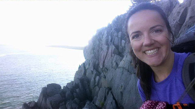 Amy Brown on the right side of the image with rocks and water in the background