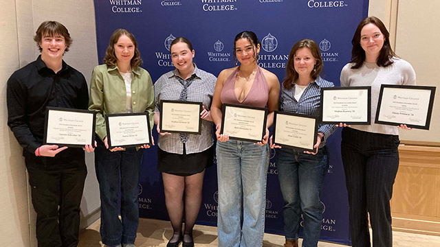 Six students holding framed certificates