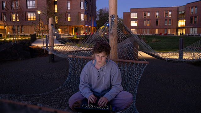 Maura Kelly sits in an outdoor hammock with a laptop