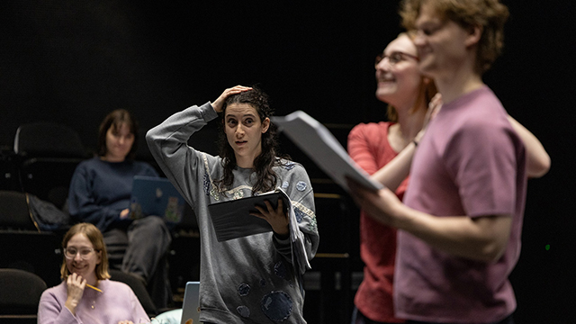 Students rehearsing with scripts in hand