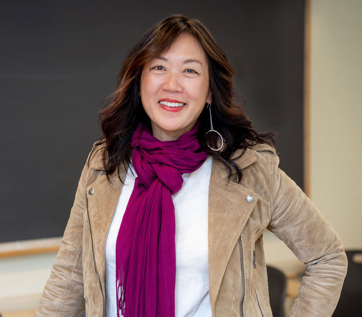 Belle Liang stand in front of a blackboard