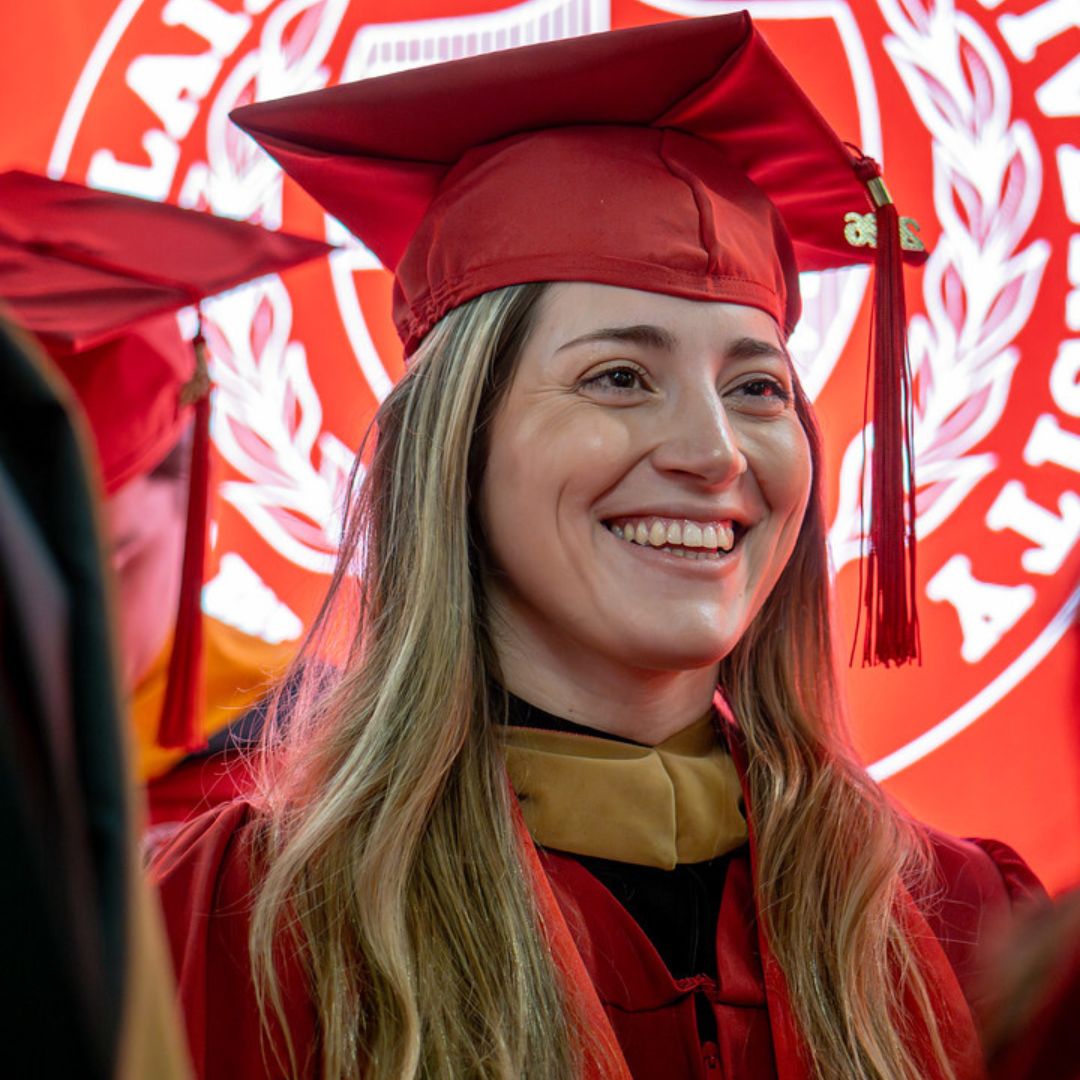 Graduate student smiling with pride at Commencement.