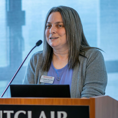 Photo of Vice Provost of Research Dr Stefanie Brachfeld speaking at a podium.