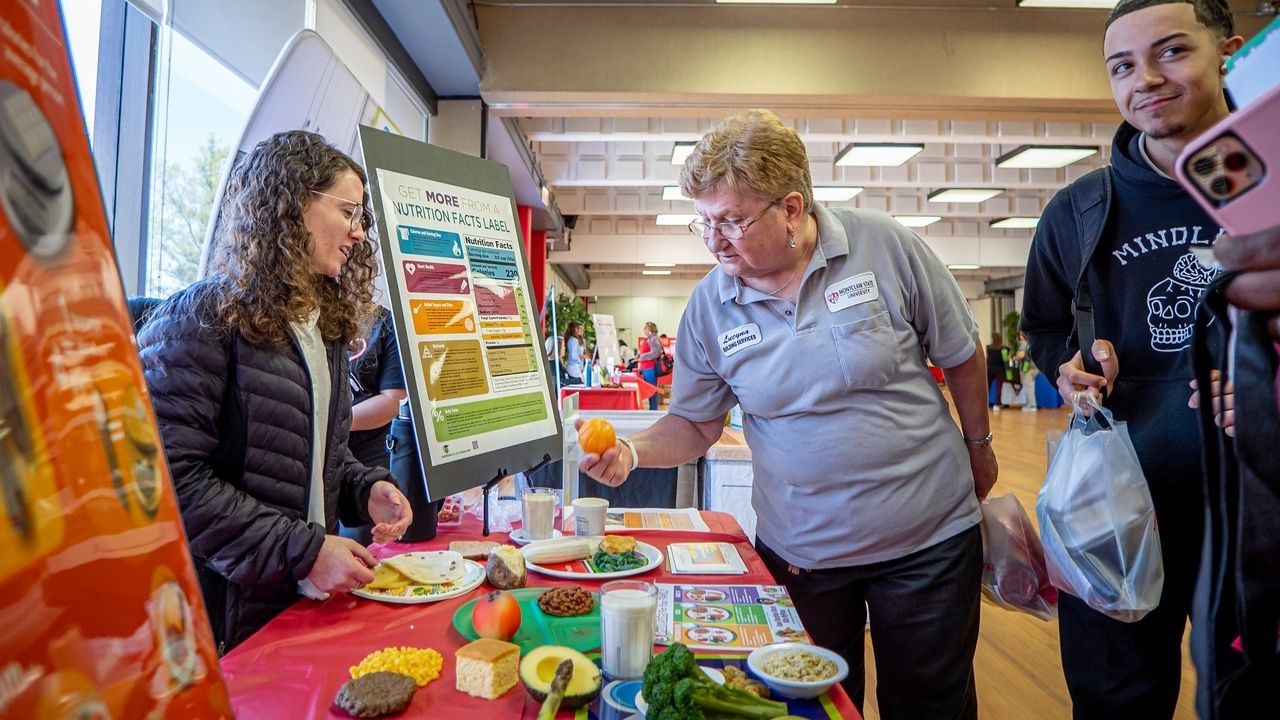 University Facilities employee learns more about nutritional health at an informational table.