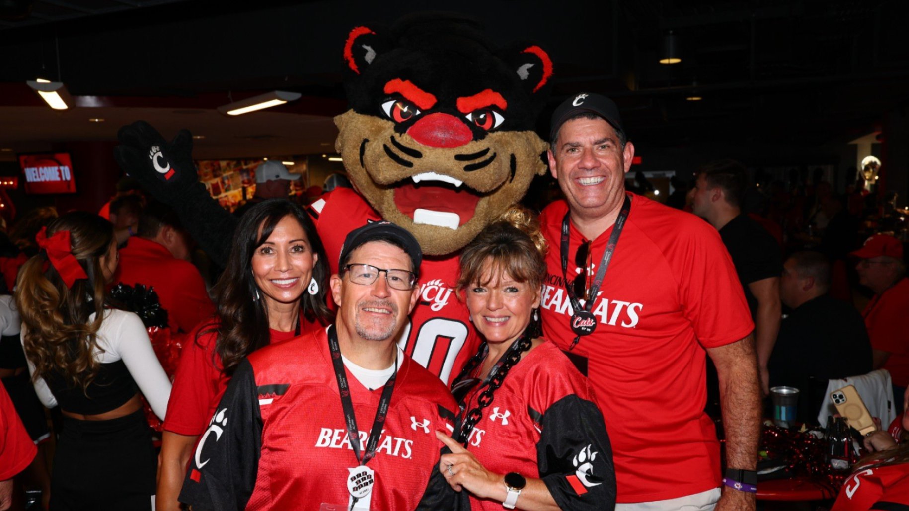 Alum posing with Bearcat Mascot at a Bearcats on the Road event