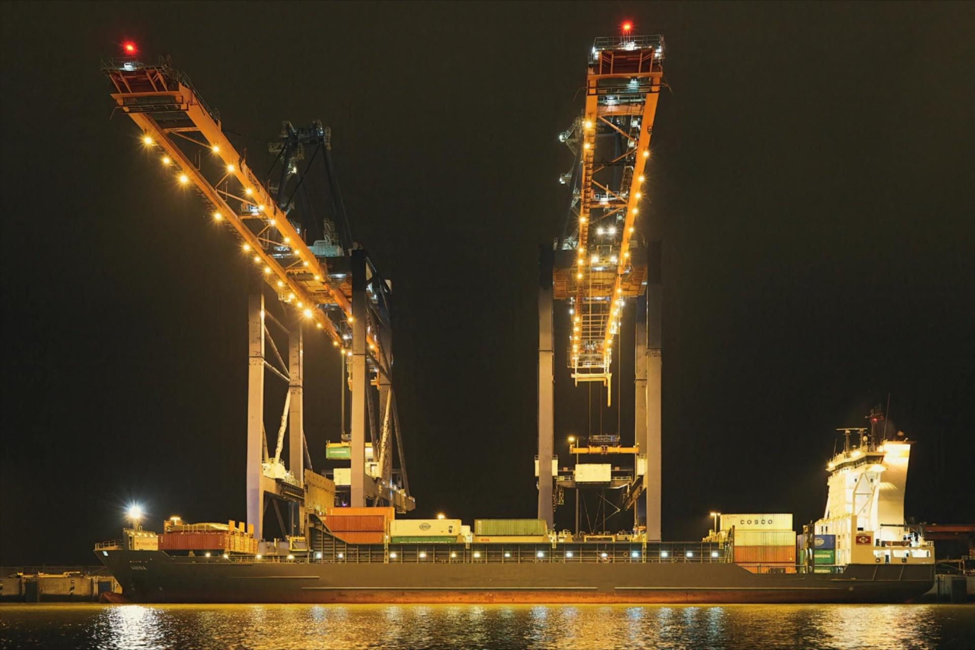 Image of offshore cranes in the night sky.