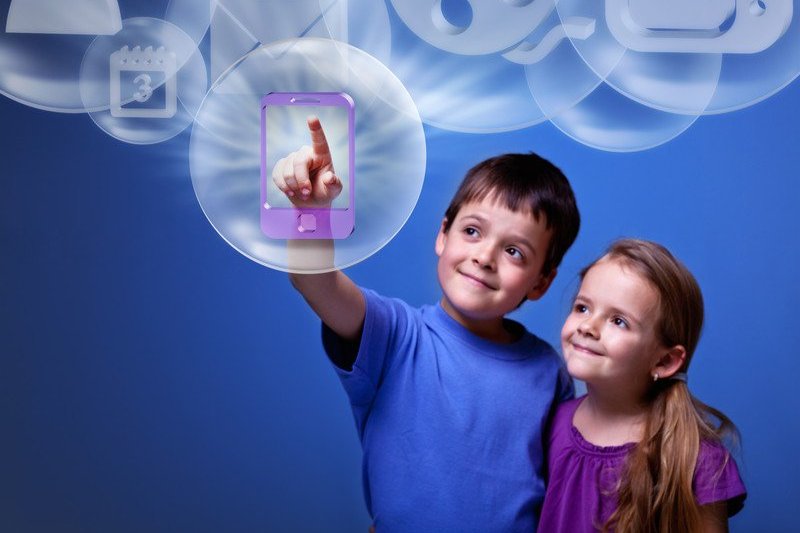 a boy and girl touching a device