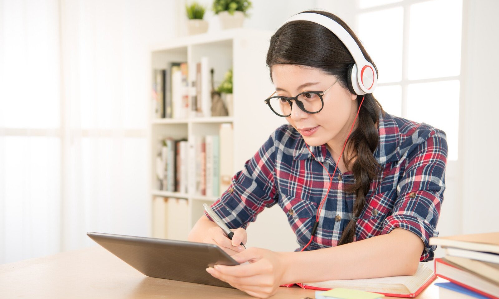 a woman wearing headphones and using a tablet