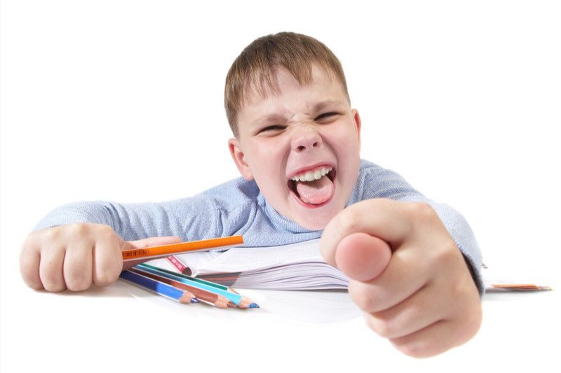 a boy with his tongue out and pointing his finger