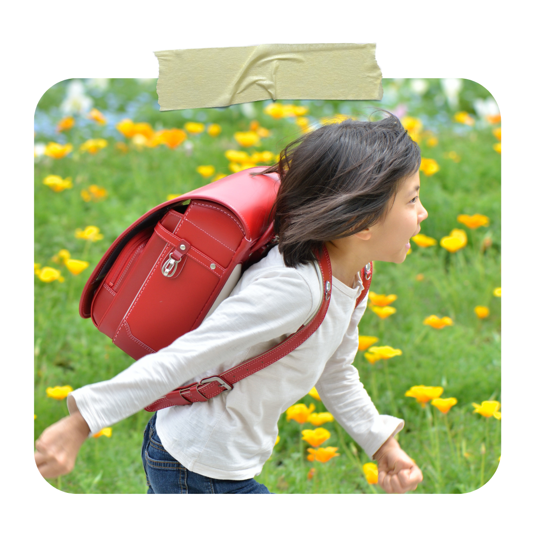 Japanese child running with a red randoseru school backpack
