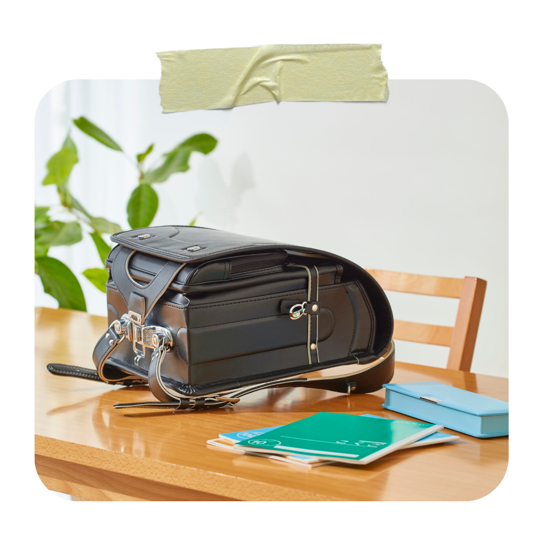 Modern black randoseru with notebooks and Japanese school supplies